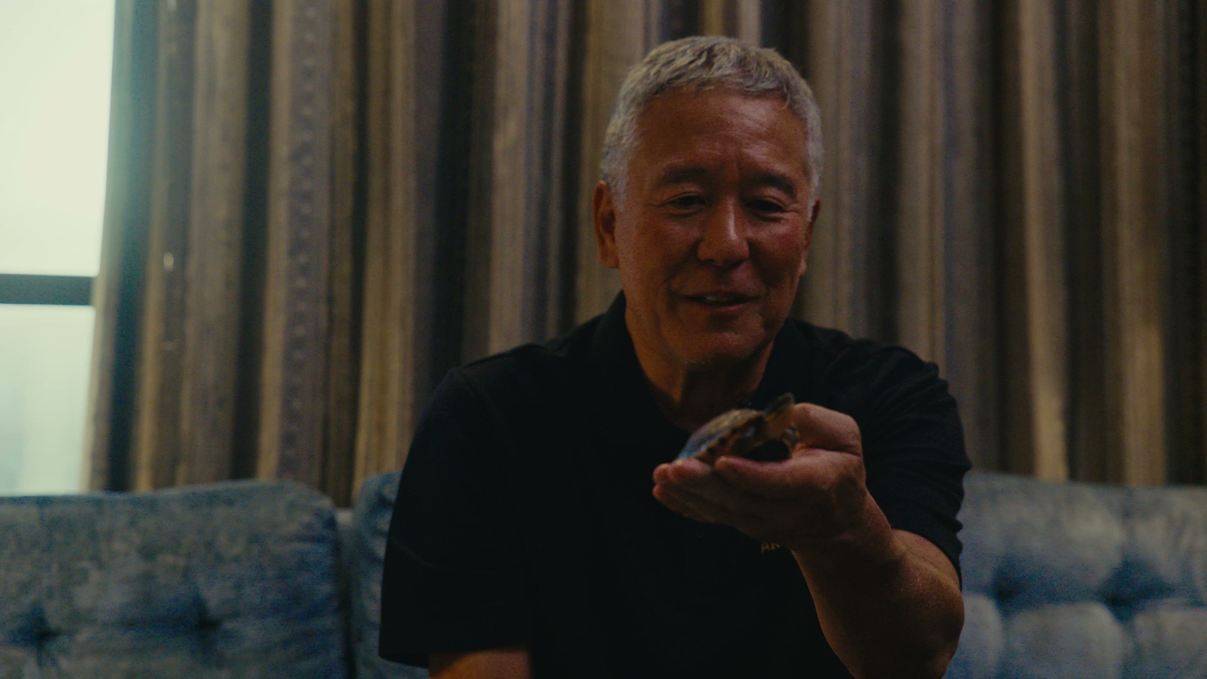 Eric Akaba holding a young turtle during his Archelon interview